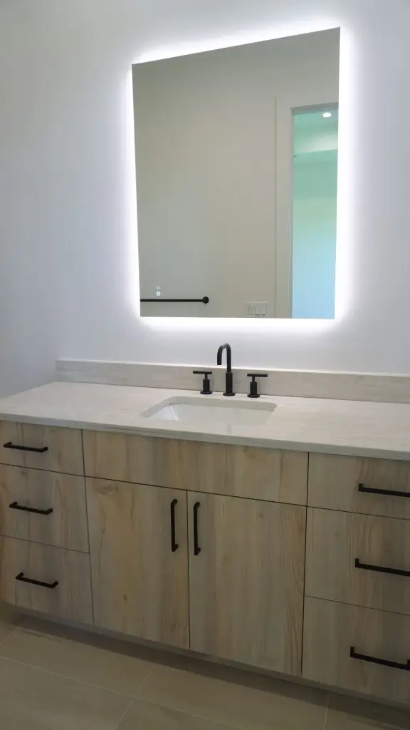Bathroom in a Longboat Key new build featuring dual LED mirrors and custom design by Florida Design Works.