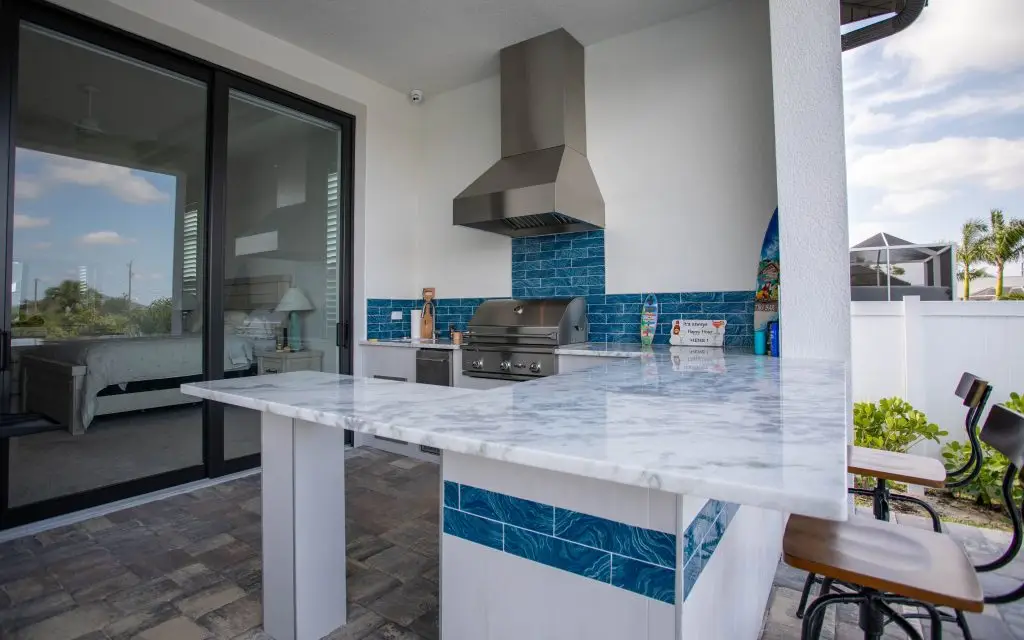 Remodeled outdoor kitchen in Bradenton, Florida featuring sleek white and glossy countertops, and custom cabinetry by Florida Design Works.